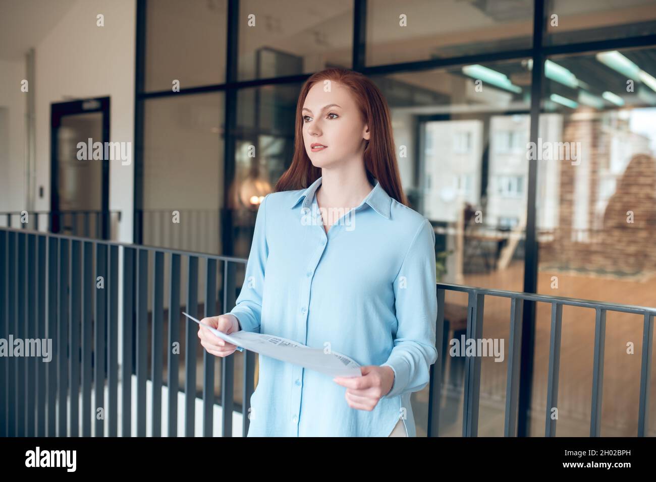 Femme pensive avec plan de construction entre les mains Banque D'Images