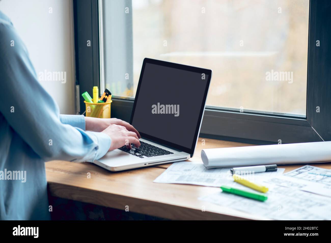 Les mains des femmes près du clavier de l'ordinateur portable sur le rebord de la fenêtre Banque D'Images