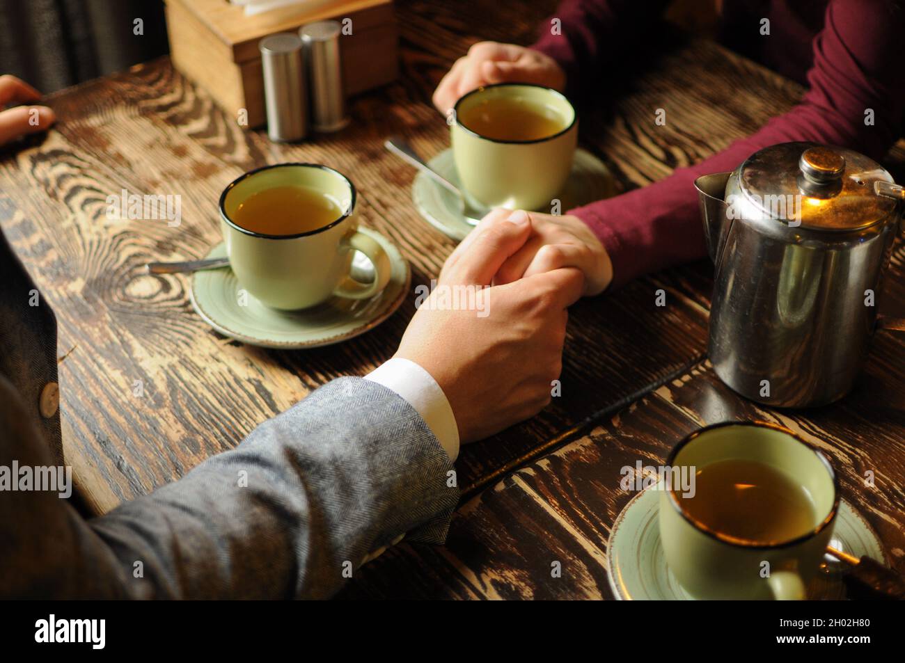 Couple marié ont une date, boire du thé et tenir les mains dans un café par  temps froid Photo Stock - Alamy