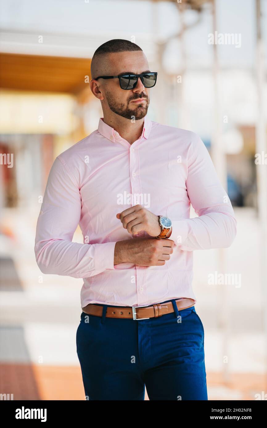 Cool beau homme caucasien portant une elegante chemise rose clair et des lunettes de soleil posant a l exterieur Photo Stock Alamy