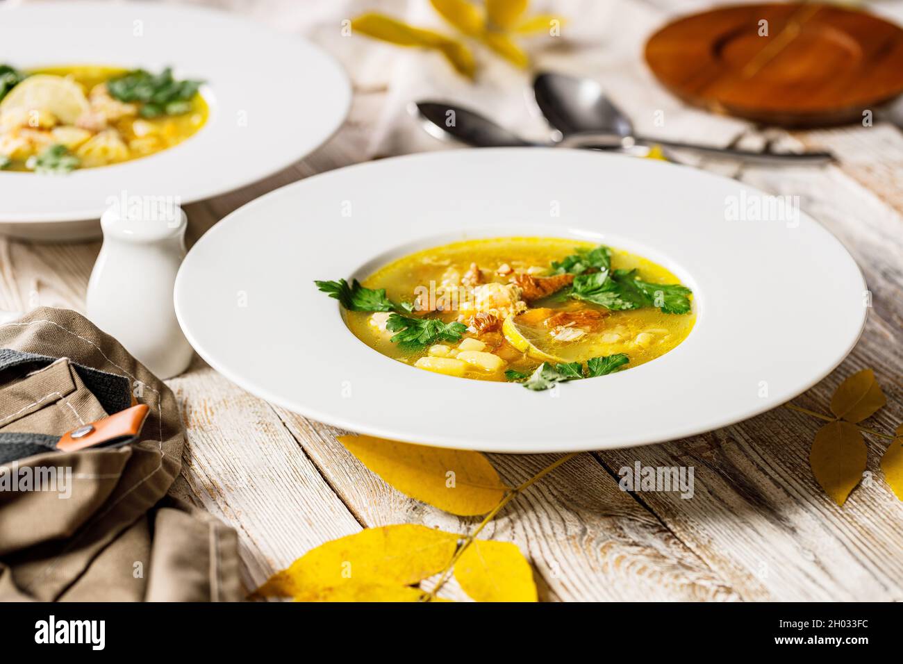 Délicieuse soupe d'automne avec chanterelles et herbes fraîches.Plat de saison avec champignons comestibles.Assiette blanche et couverts sur un fond rustique.Nourriture ist Banque D'Images