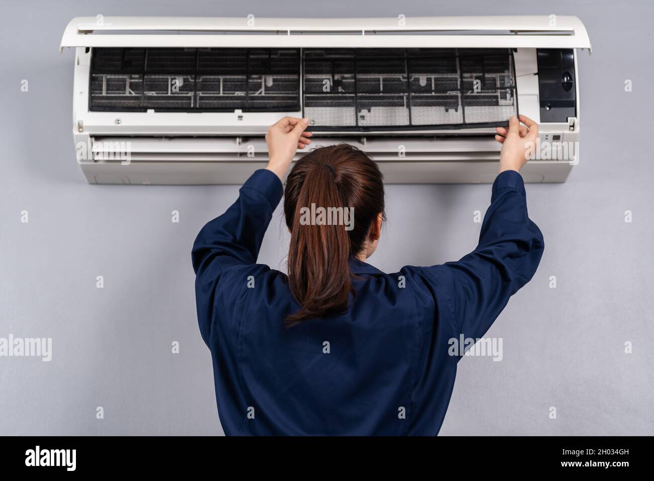 technicien de maintenance féminin pour la dépose du filtre à air du  climatiseur pour le nettoyage Photo Stock - Alamy