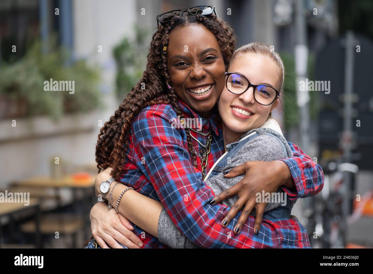 Portrait de deux filles de meilleurs amis interraciaux qui s'embrasent dans les rues.Étudiants filles s'amuser ensemble. Banque D'Images