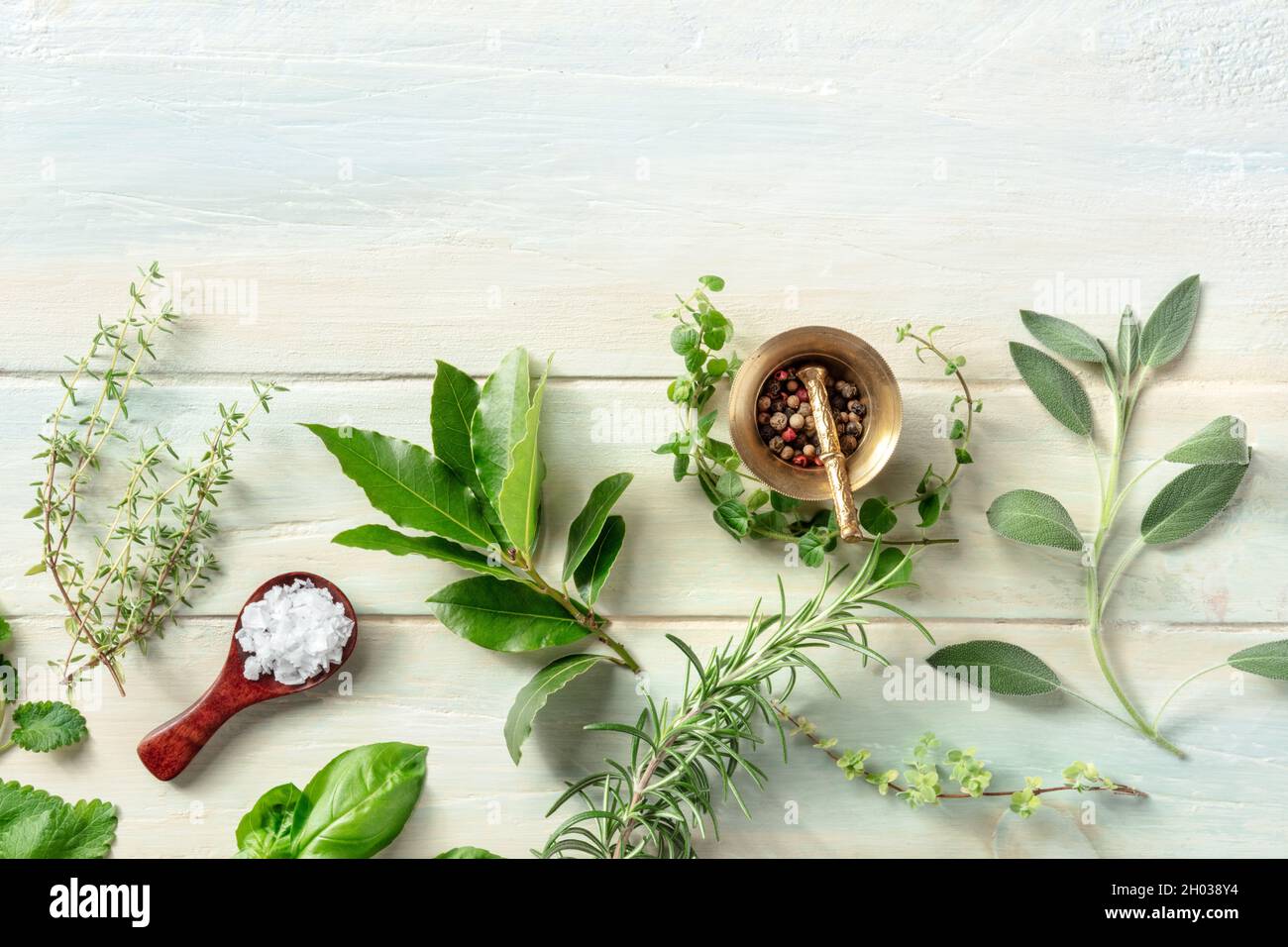 Cuisson avec des herbes.Un modèle de conception culinaire avec sel, poivre et herbes aromatiques, plan de dessus plat sur un fond rustique en bois Banque D'Images