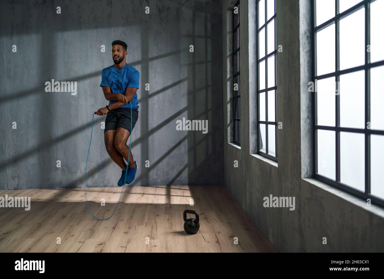 Jeune sportif afro-américain utilisant la corde de saut à l'intérieur, concept d'entraînement. Banque D'Images