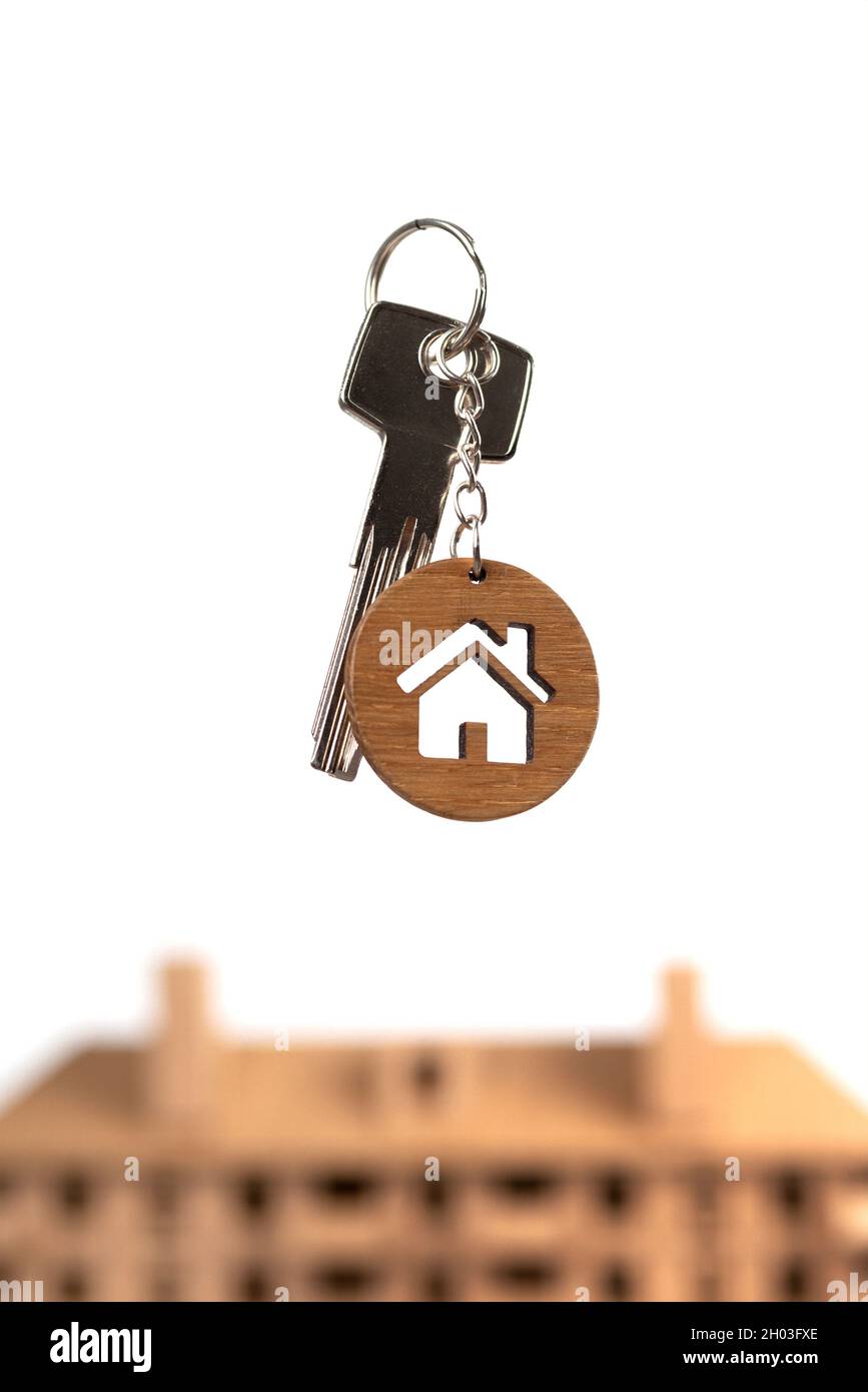 Concept immobilier.Clés avec porte-clés en forme de maison contre modèle brun. Banque D'Images