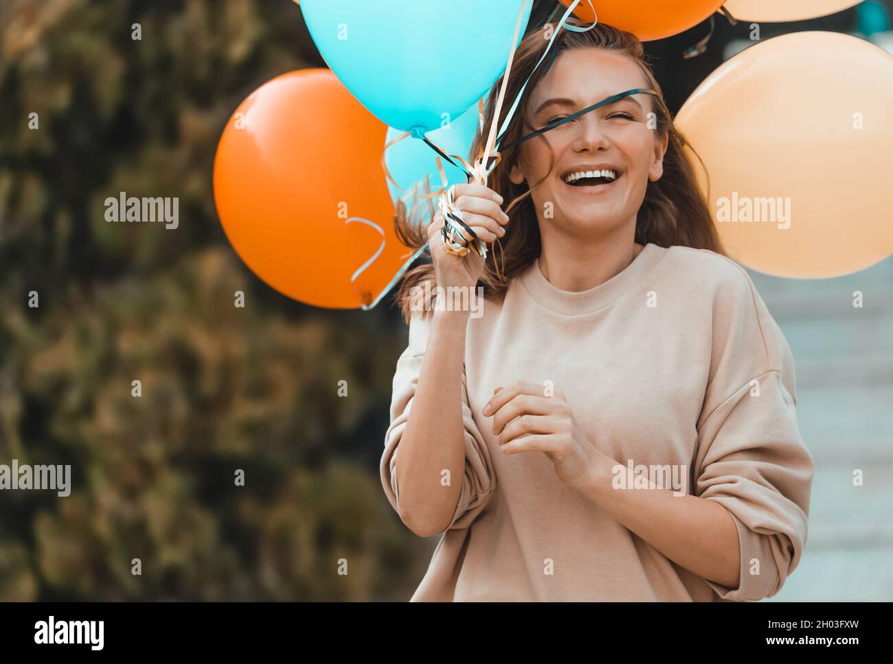 Portrait d'une belle femme souriante avec des ballons d'air colorés ayant l'amusement à l'extérieur.Profitez de la fête d'anniversaire dans la chaude Sunny Day sur l'arrière-cour. Banque D'Images