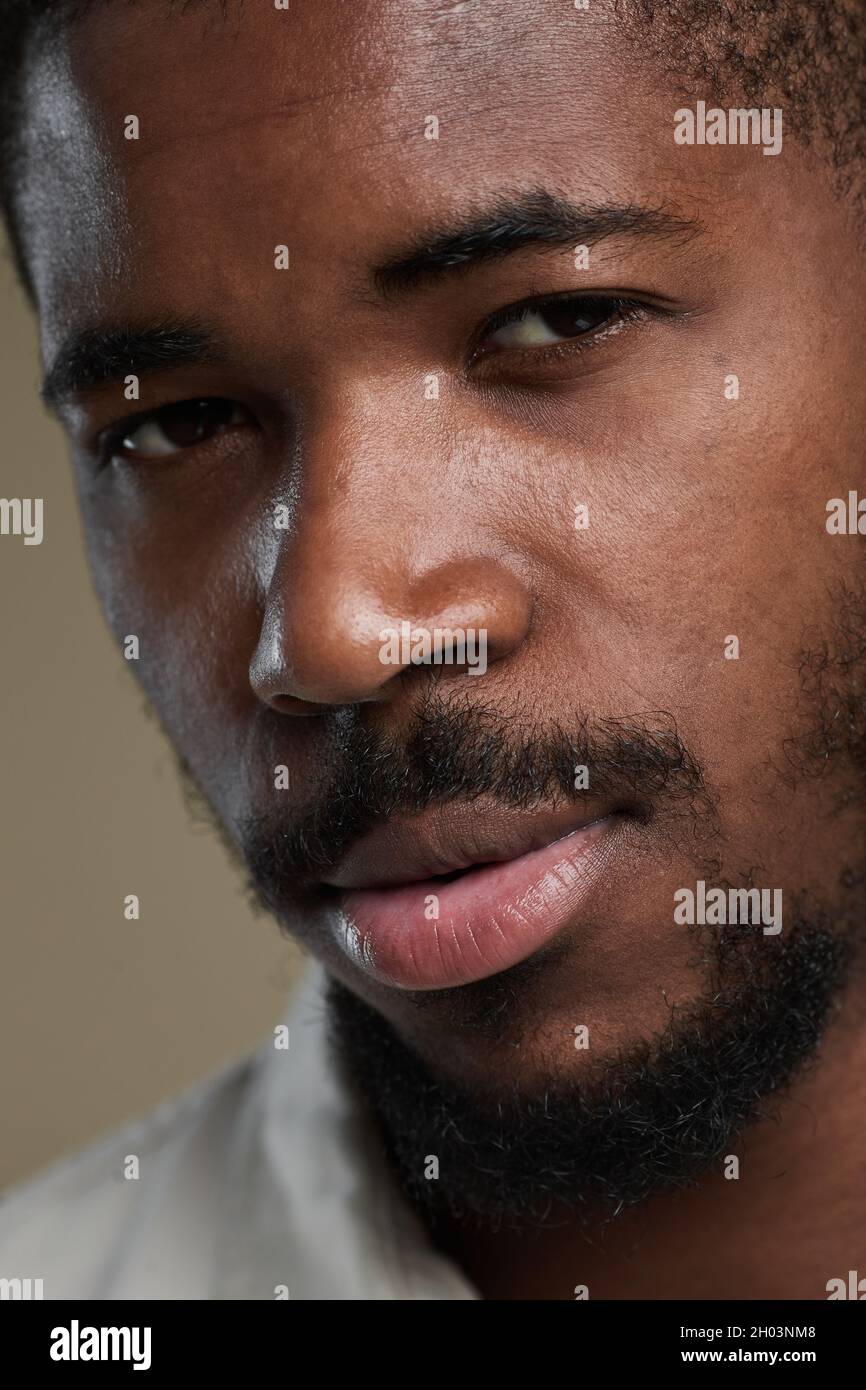 Portrait extrêmement gros plan d'un beau homme afro-américain regardant l'appareil photo Banque D'Images