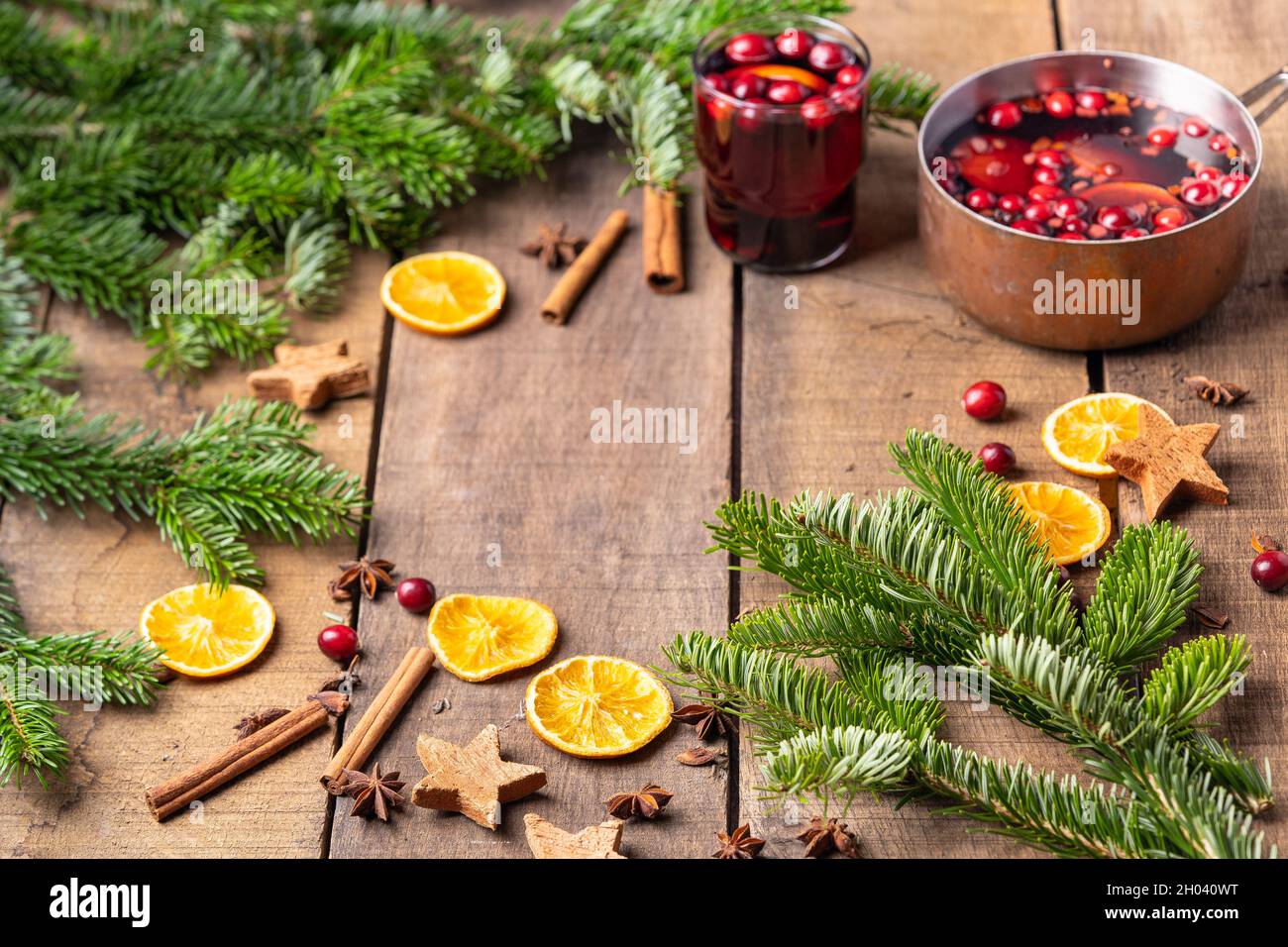 Vin chaud chaud chaud à base de vin rouge, de baies et d'oranges.Cadre de branches d'arbre de Noël, décoration pour le nouvel an et Noël Banque D'Images