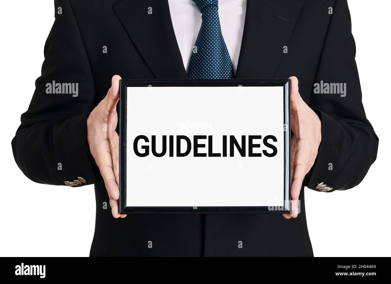 Homme d'affaires tient un panneau avec le mot lignes directrices sur fond blanc isolé.Concept de règles, de normes ou de politiques métier. Banque D'Images
