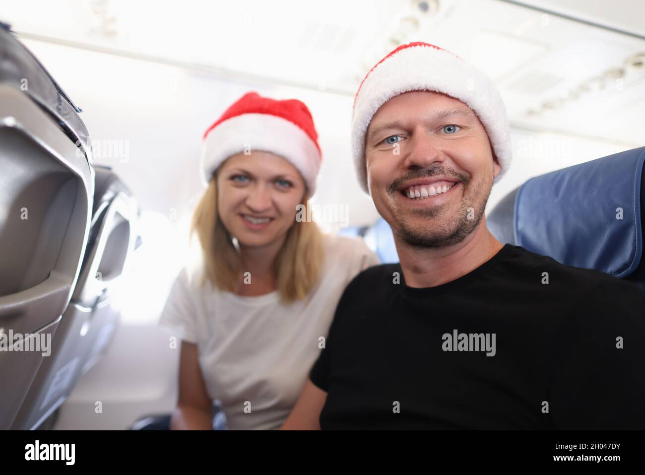 Homme et femme en rouge chapeau de père noël volant dans l'avion Banque D'Images