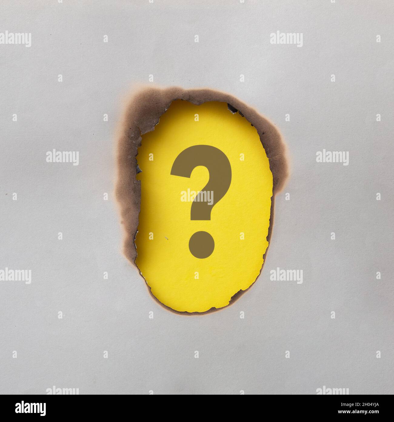 Point d'interrogation sur carte jaune ou papier encadré de papier gris brûlé avec espace de copie pour une image créative conceptuelle Banque D'Images