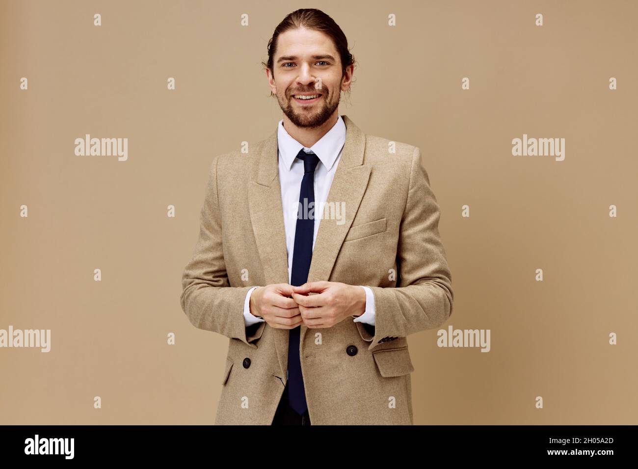 homme en veste beige dans un costume avec une cravate posant un  arrière-plan isolé Photo Stock - Alamy