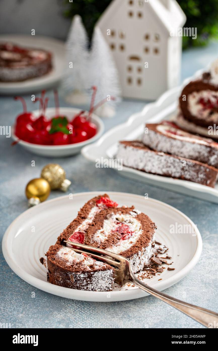 Rouleau de gâteau de forêt noire avec crème fouettée et cerises Banque D'Images