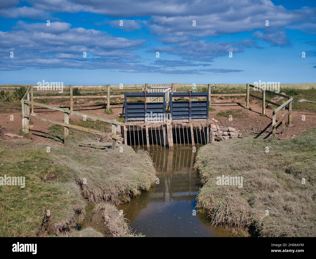Défenses contre les crues dans les marais salants de basse altitude autour de South Low près de Goswick dans Northumberland, Angleterre, Royaume-Uni.Pris par une journée ensoleillée en été. Banque D'Images