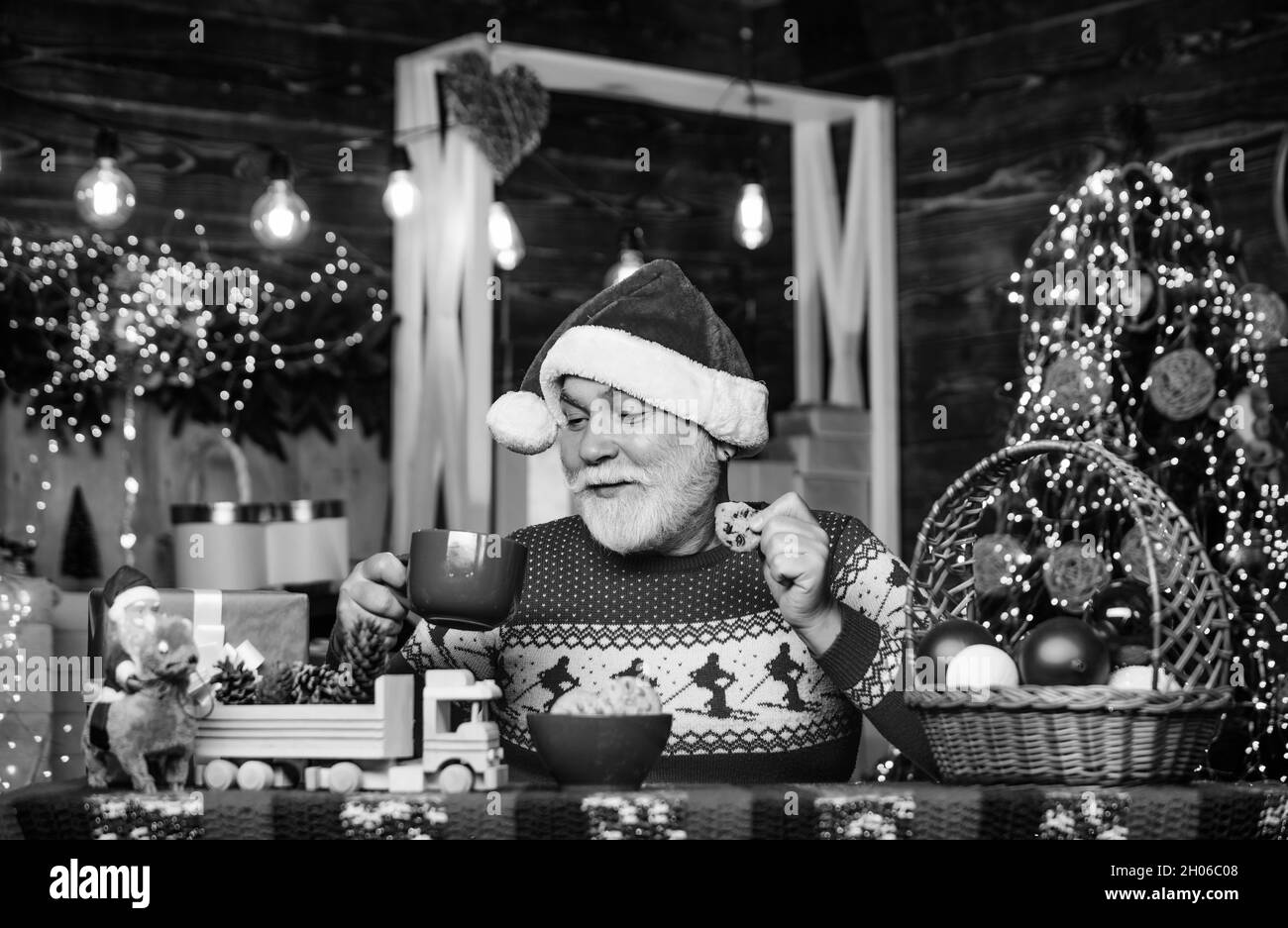Guirlande lumineuse atmosphère chaleureuse.Grand-père avec tasse.Fête des vacances d'hiver.Je me sens bien à la maison.Homme senior Santa claus buvant du thé.Nouvelle année Banque D'Images