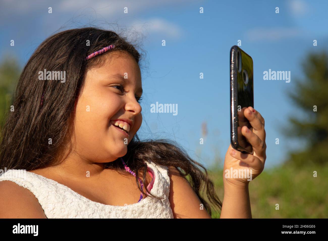 gypsy fille avec de longs cheveux noirs prend des selfies avec son smartphone Banque D'Images