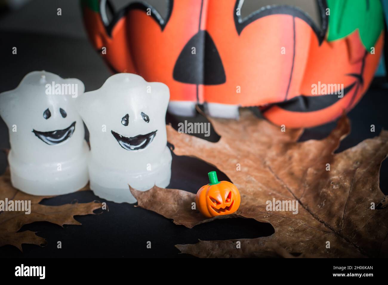 petite citrouille orange avec feuilles d'automne, bougies sur fond noir Banque D'Images