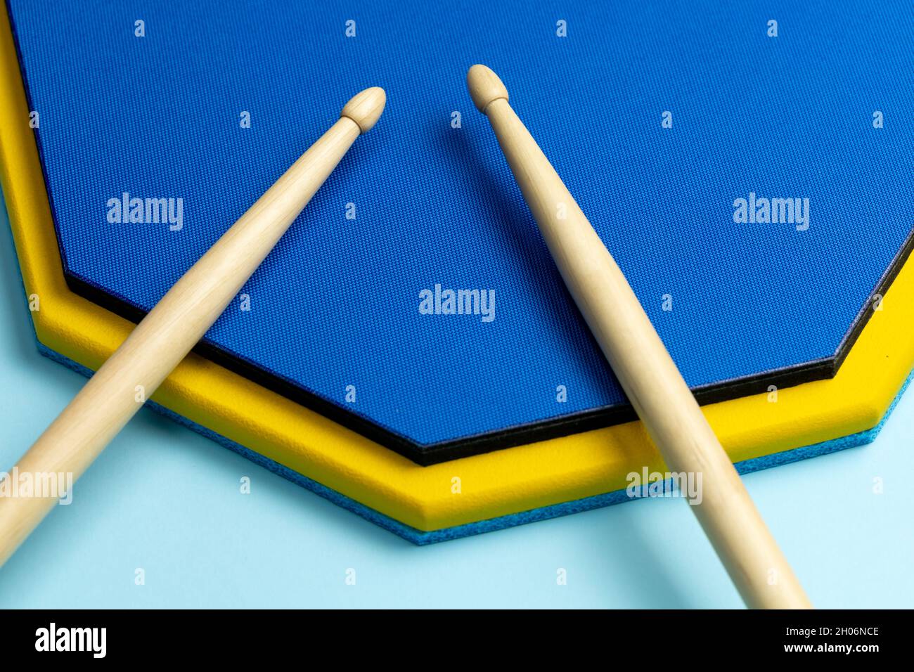 Bâtons de tambour et tapis de formation sur fond bleu. Banque D'Images