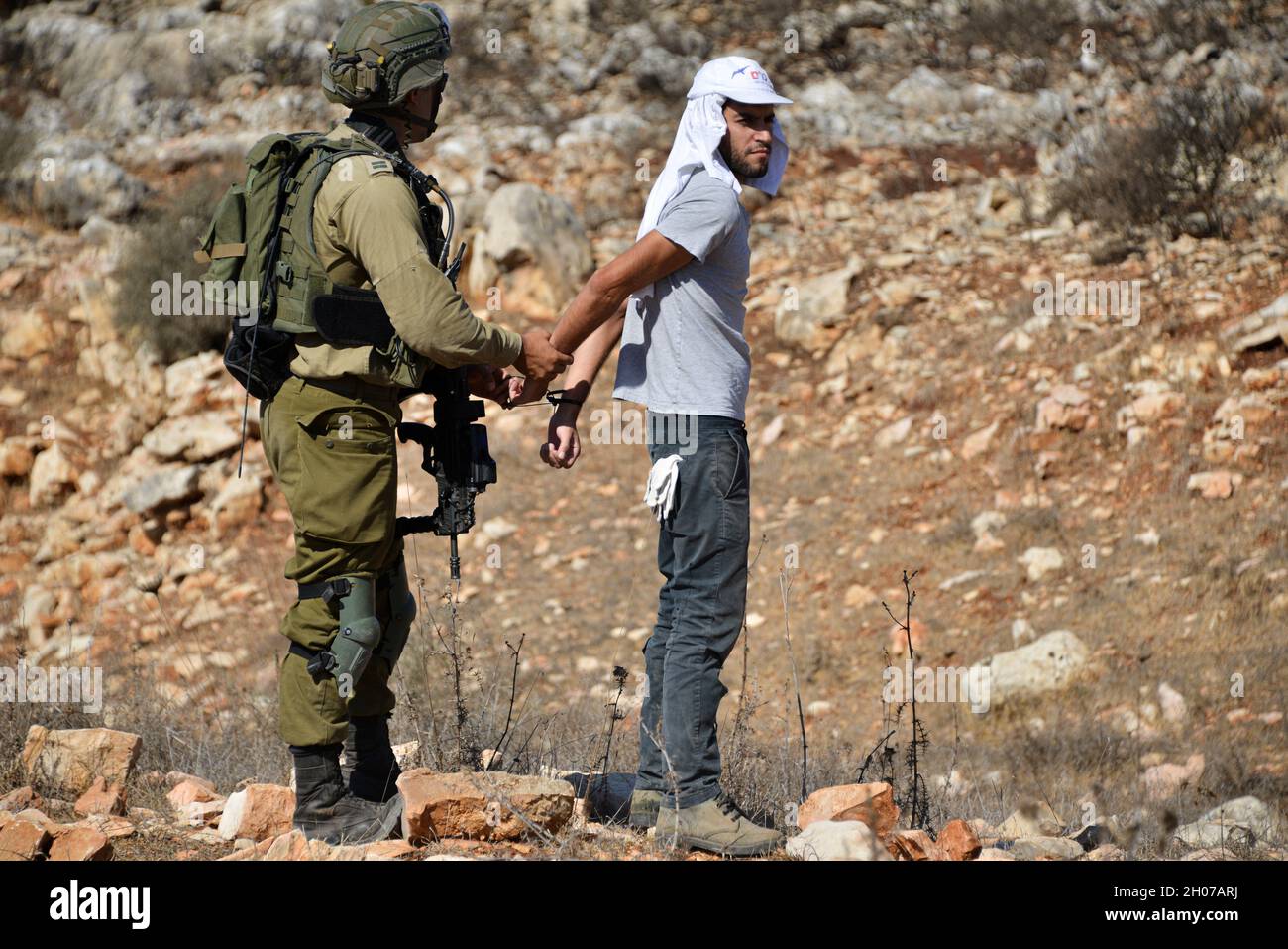 Les soldats des forces de défense israéliennes empêchent les habitants et les militants d'accéder aux plantations d'olives pendant la saison des récoltes.La plantation à la périphérie de la ville de Salfit a été annexée l'année dernière à un nouvel avant-poste juif - "AVI View Farm", bien que les Pléstins détiennent des actions terrestres pour la terre.Au cours d'une tentative de briser la ligne blanche de zonage d'une zone militaire fermée dans les plantations, l'armée a utilisé des grenades lapiantes et arrêté trois activistes.Salfit, Cisjordanie, le 11 octobre 2021.(Matan Golan/Alay Live News) Banque D'Images