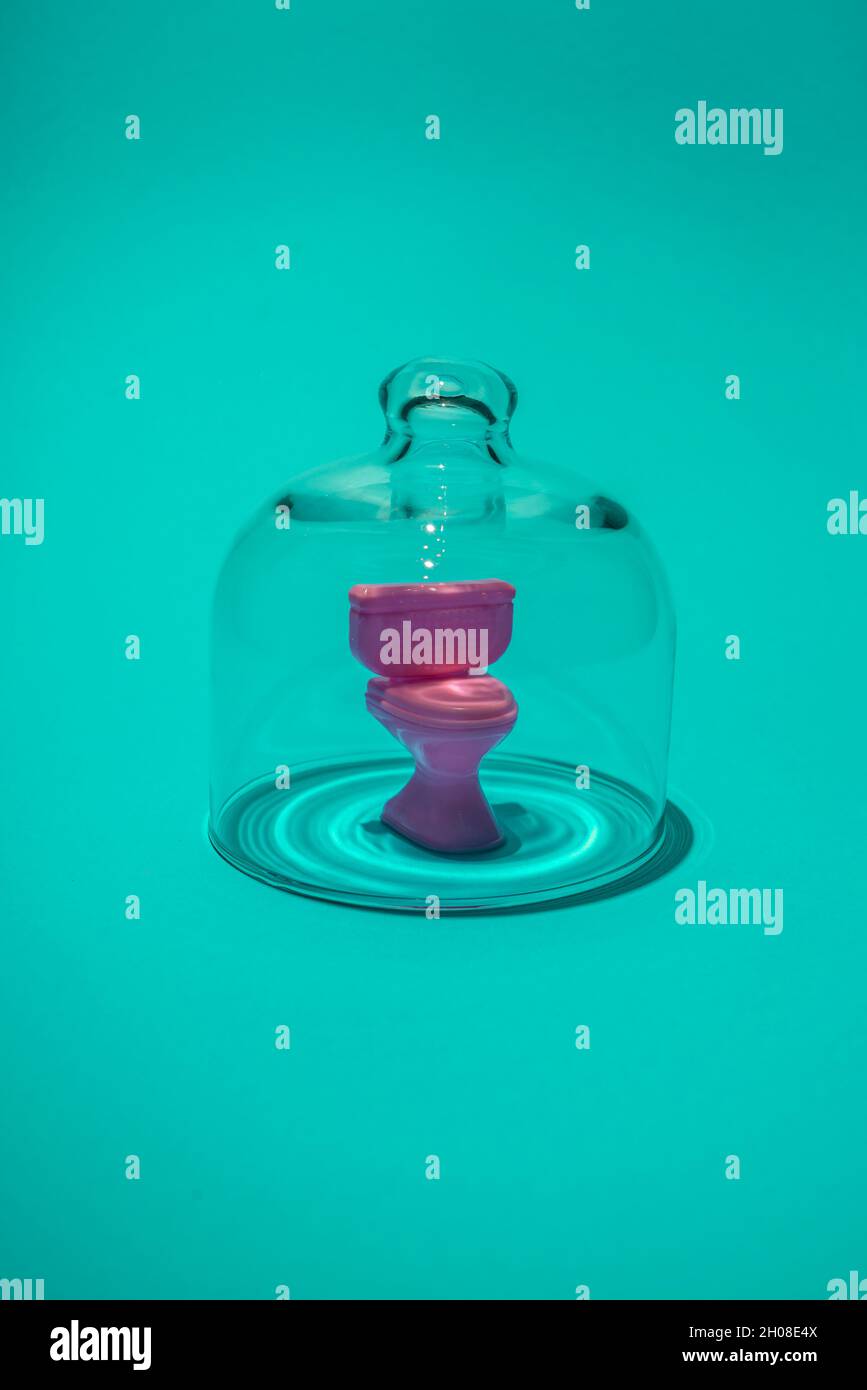Siège de toilette sous cloche en verre.Idée d'hygiène.Concept abstrait minimal de pandémie et d'isolement.Avec espace de copie. Banque D'Images
