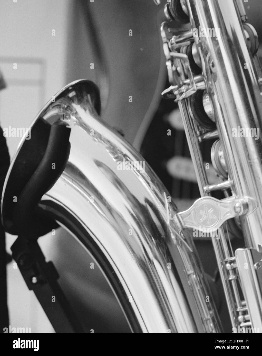 Prise de vue en niveaux de gris d'un saxophone sous les lumières avec un arrière-plan flou Banque D'Images