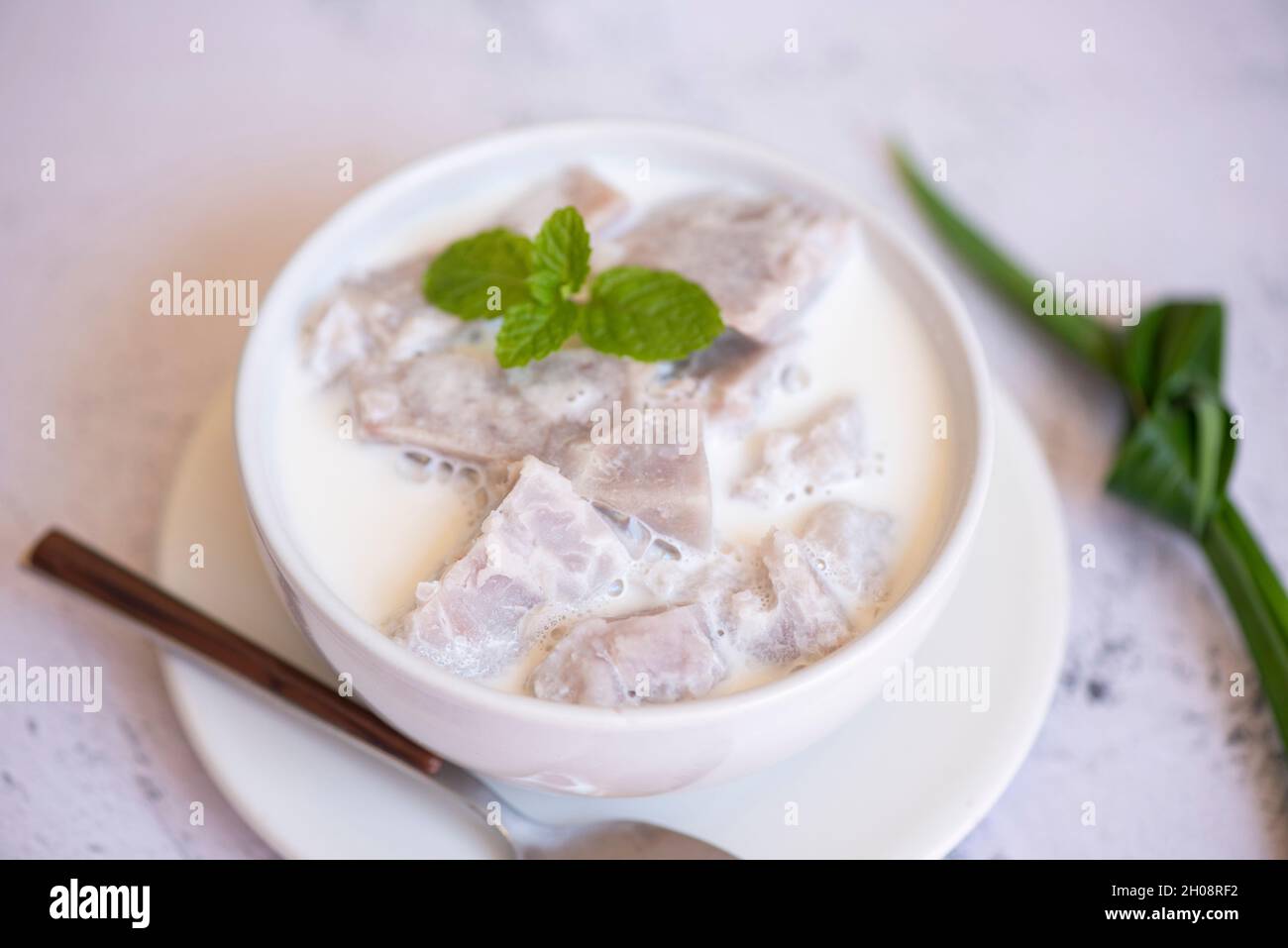 Taro alimentaire avec dessert taro bouilli avec du sucre et du lait de coco sur un bol et de la racine de taro frais cru bio prêt à cuire, cuisine thaïlandaise asiatique Banque D'Images