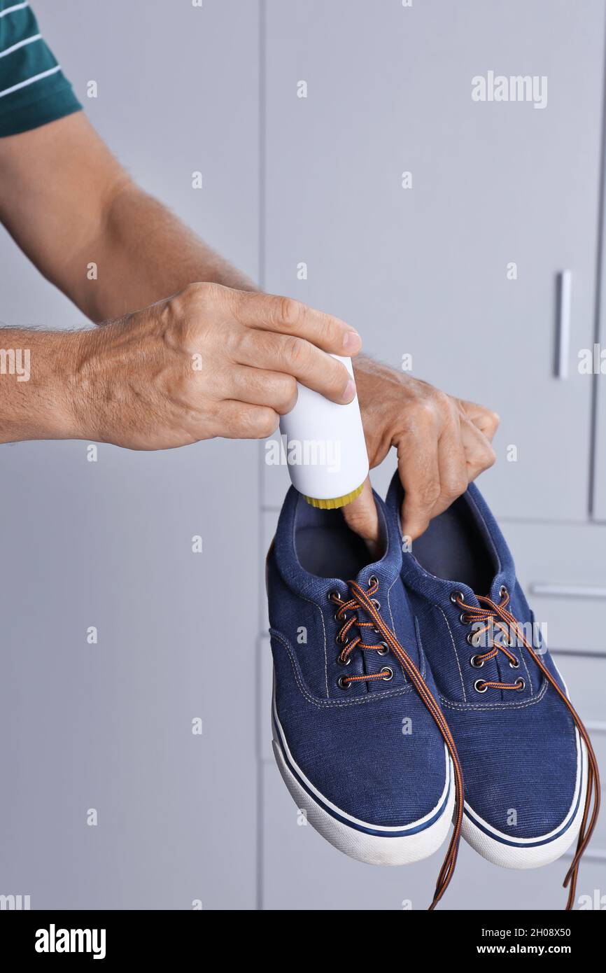 Homme en train de mettre du désodorisant pour chaussures en poudre dans les  chaussures à l'intérieur, gros plan Photo Stock - Alamy