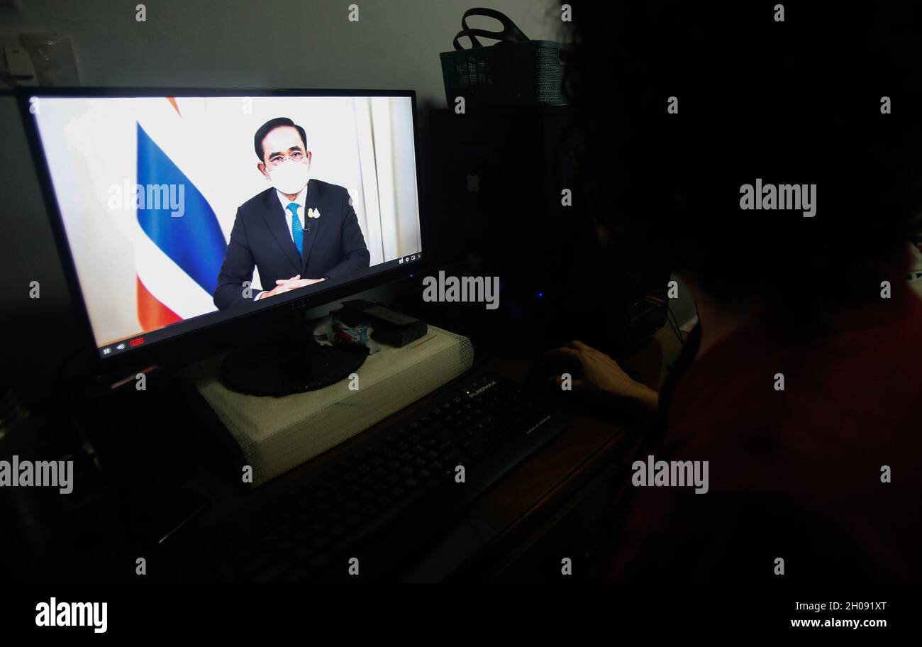 Une femme regardant la capture de télévision montre le Premier ministre thaïlandais Prayuth Chan O-Cha faisant un discours télévisé en direct.le premier ministre a déclaré lundi que les visiteurs sont tenus de porter le document de résultat de test RT-PCR (réaction de la chaîne de transcription inverse de la polymérase) avant d'entrer et de quitter le pays.Le gouvernement vise à permettre à davantage de pays de se rendre en Thaïlande d'ici décembre, alors que la prochaine phase devrait être le 1er janvier 2022.Pendant ce temps, la consommation d'alcool dans les restaurants et les lieux de divertissement qui rouvrent seront considérés pour approbation le 1er décembre.(Photo de Chaiw Banque D'Images