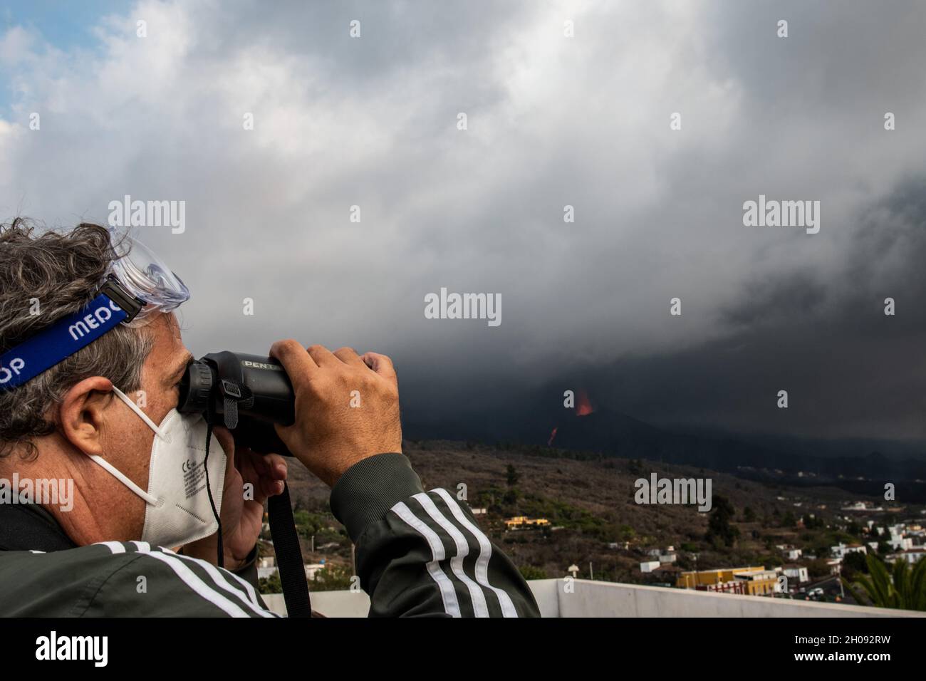 La Palma, Espagne.11 octobre 2021.Un homme regarde à travers ses jumelles le volcan Cumbre Vieja de Tajuya.Le volcan Cumbre Vieja continue d'éclater de lave avec de nouveaux ruisseaux atteignant les zones industrielles et résidentielles.Credit: Marcos del Mazo/Alay Live News Banque D'Images