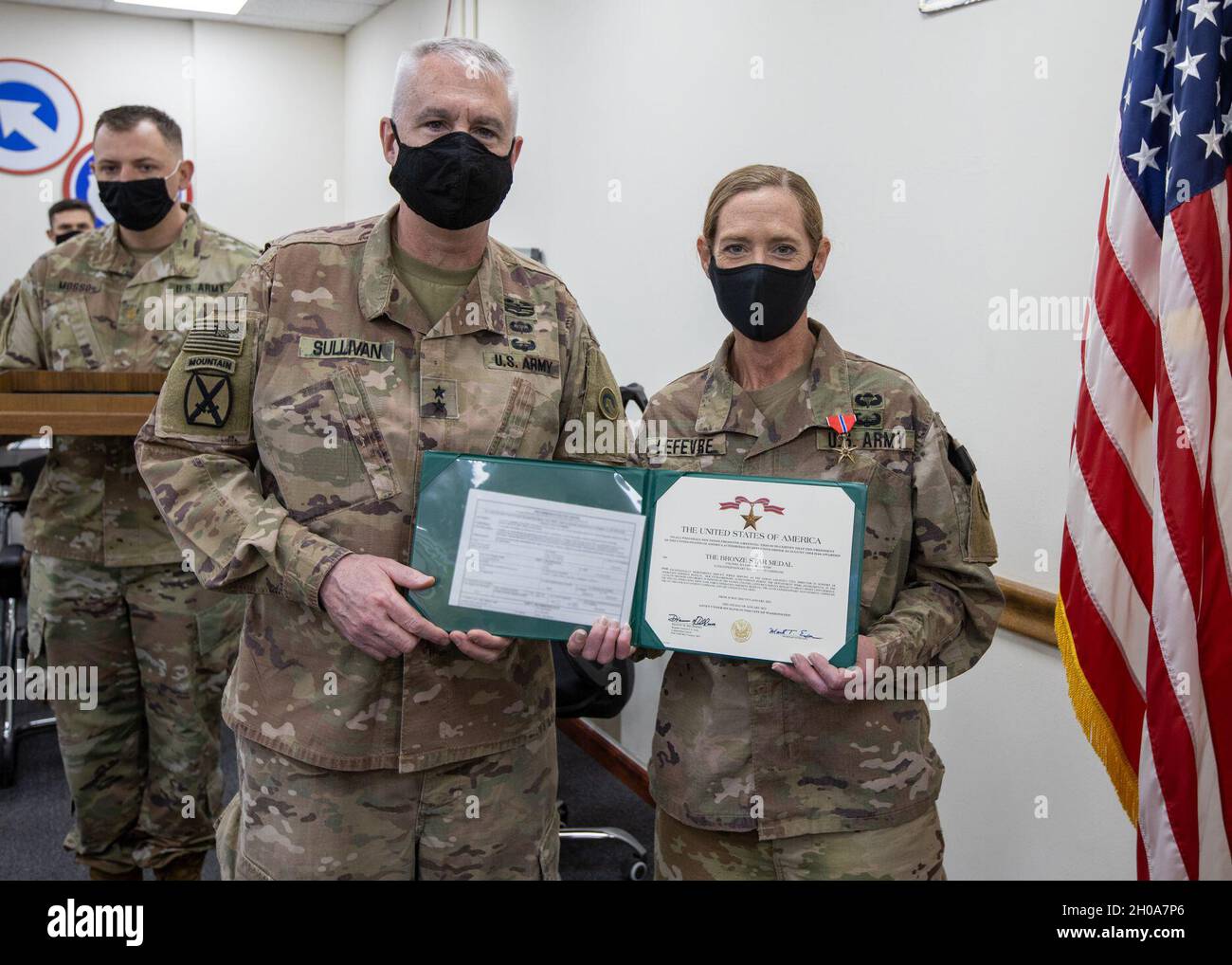 Le général de division John P. Sullivan, commandant général du 1er Commandement du soutien du théâtre, présente une étoile de bronze au colonel Julianne M. Lefevre, directrice de la cellule de logistique syrienne, 311e Commandement du soutien expéditionnaire, lors d'une cérémonie de remise des prix le 6 janvier 2021 au Camp Arifjan, au Koweït.Le travail acharné et le service désintéressé de Lefevre lui font porter un grand crédit, à lui et à l’Armée américaine. Banque D'Images