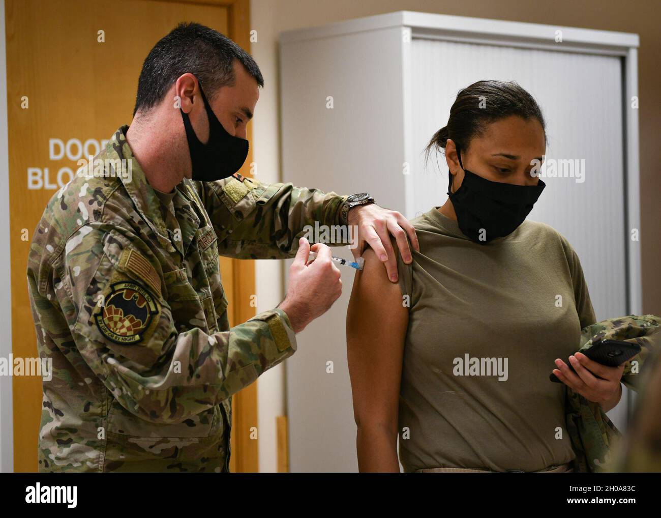 Un technicien médical affecté au 48e groupe médical remet le vaccin COVID-19 à un Airman de la Royal Air Force Lakenheath, en Angleterre, le 6 janvier 2021.Chaque phase du processus de distribution des vaccins est conçue pour inoculer en toute sécurité le personnel du ministère de la Défense de la COVID-19 le plus rapidement possible. Banque D'Images