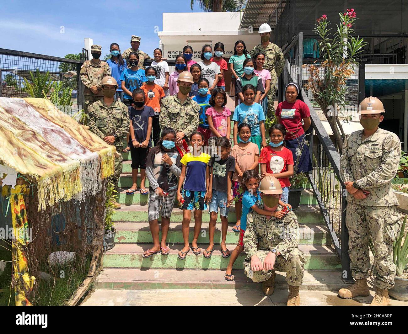 210106-N-UN063-1082 DILI, Timor-Leste (janv6, 2021) Seabés affectés au bataillon de construction mobile navale des États-Unis (NMCB) 3 détail Timor-Leste pose pour une photo avec les soldats et les enfants de l'armée américaine après avoir remis des tables de pique-nique et de la nourriture à Irmãs Missionárias Dominicanas do Rosario Timor-Leste Orphanage.Le NMCB-3 est déployé dans la région Indo-Pacifique et effectue des travaux de construction de haute qualité afin d'aider les États-Unis et les pays partenaires à renforcer les partenariats, à décourager l'agression et à permettre la logistique expéditionnaire et la projection de la puissance navale.Le bataillon est prêt à terminer la tâche assignée, le souper Banque D'Images