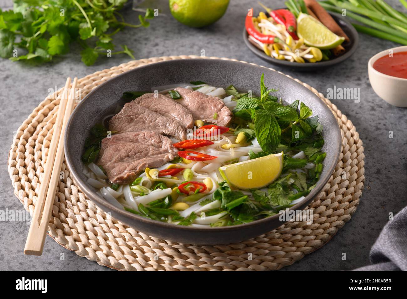 Soupe Pho Bo au bœuf dans un bol gris sur une table en pierre grise.Gros  plan.Cuisine vietnamienne et asiatique Photo Stock - Alamy
