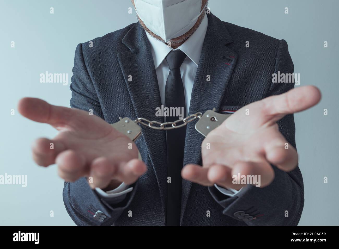 Homme d'affaires menotté avec masque respiratoire KN95, foyer sélectif Banque D'Images