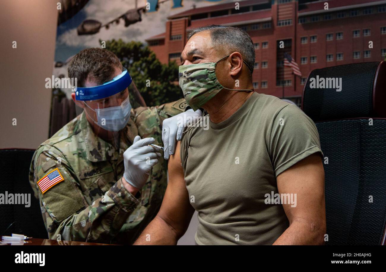 Le général Michael X. Garrett, commandant général du Commandement des Forces armées des États-Unis, reçoit la vaccination COVID-19 du SPC.Evan McBee, medic, au Womack Army Medical Center, à fort Bragg, Caroline du Nord, le 11 janvier 2021.Les vaccins Pfizer et Moderna fonctionnent en utilisant des molécules porteuses d'informations transitoires (ARNm) pour enseigner à nos cellules à fabriquer une protéine qui déclenche la formation d'anticorps pour créer une réponse immunitaire dans notre corps.L’ARNm est synthétique et non extrait des virus réels, et il n’entre pas dans l’ADN de votre organisme et n’interagit pas avec celui-ci.Le vaccin COVID-19 se compose de deux doses administrées par abo Banque D'Images