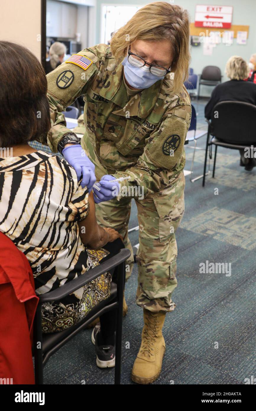 Sergent d'état-major de l'armée américaineStacie Tindle, une médaillée affectée au 130e pont d'amélioration de la manœuvre, administre le vaccin COVID-19 à un patient du département de santé publique du comté de Forsyth à Winston-Salem, en Caroline du Nord, le 12 janvier 2021.Gov.Roy Cooper a mobilisé le CNG pour fournir un soutien aux fournisseurs de soins de santé locaux en augmentant leurs opérations de distribution et de vaccination. Banque D'Images