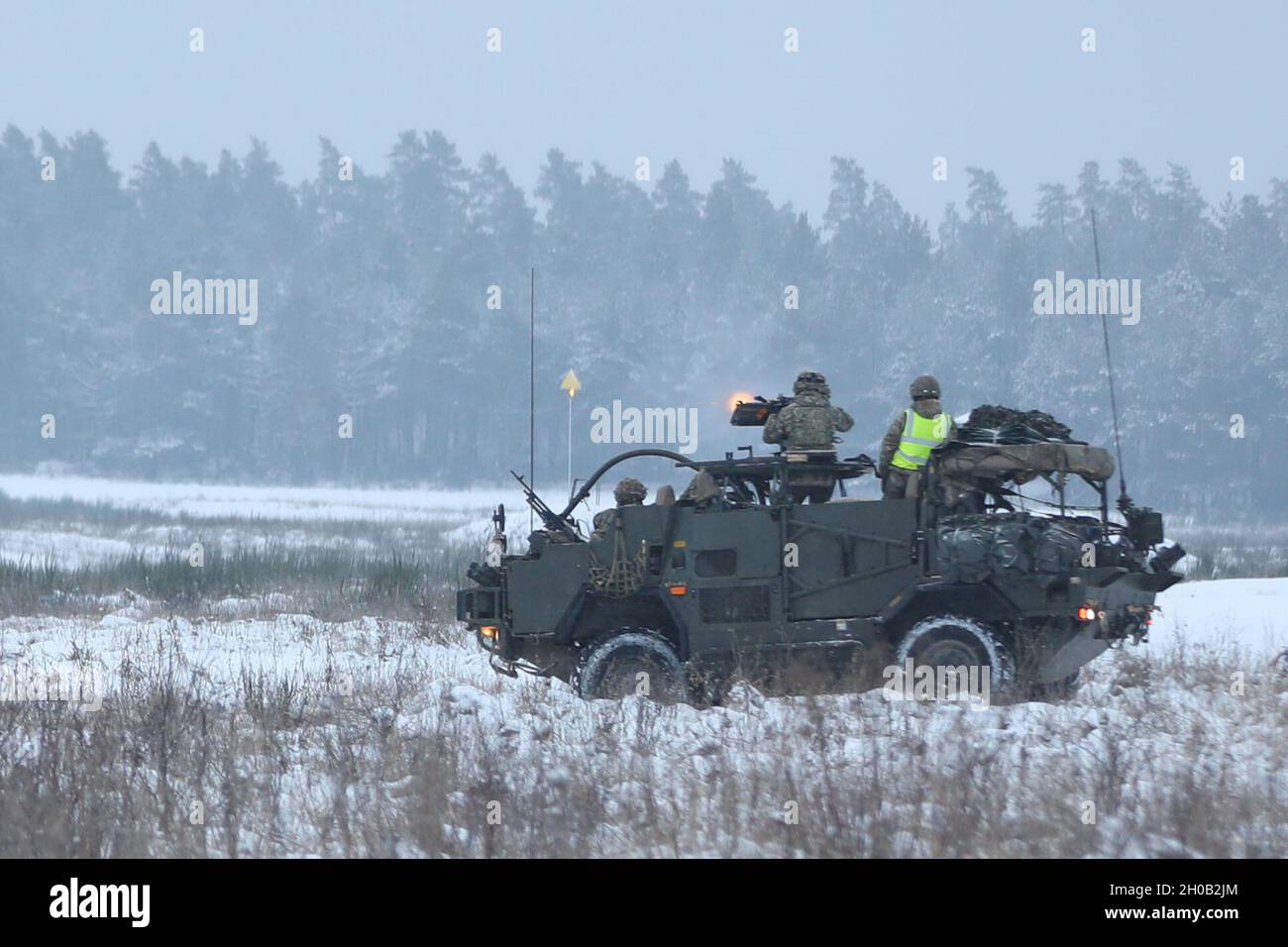 Un éclair de feu s'émet à partir de 0,50 cal. Alors que les troupes de Cassino britanniques du groupement tactique de présence avancée renforcée Pologne ont tiré sur des cibles lors d'un cours d'opérateur d'armes à plate-forme sur une aire enneigée le 14 janvier 2021, dans la zone d'entraînement de Bemowo Piskie. Banque D'Images
