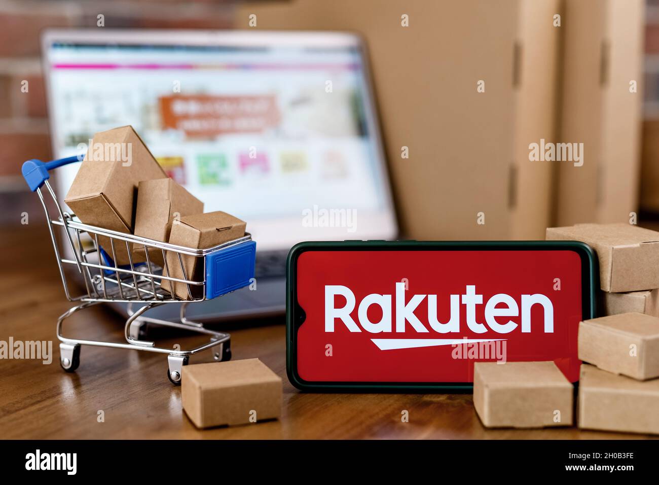 Rakuten Group est une entreprise japonaise de commerce électronique et de vente au détail en ligne.Smartphone avec logo Rakuten à l'écran, panier et ordinateur portable. Banque D'Images