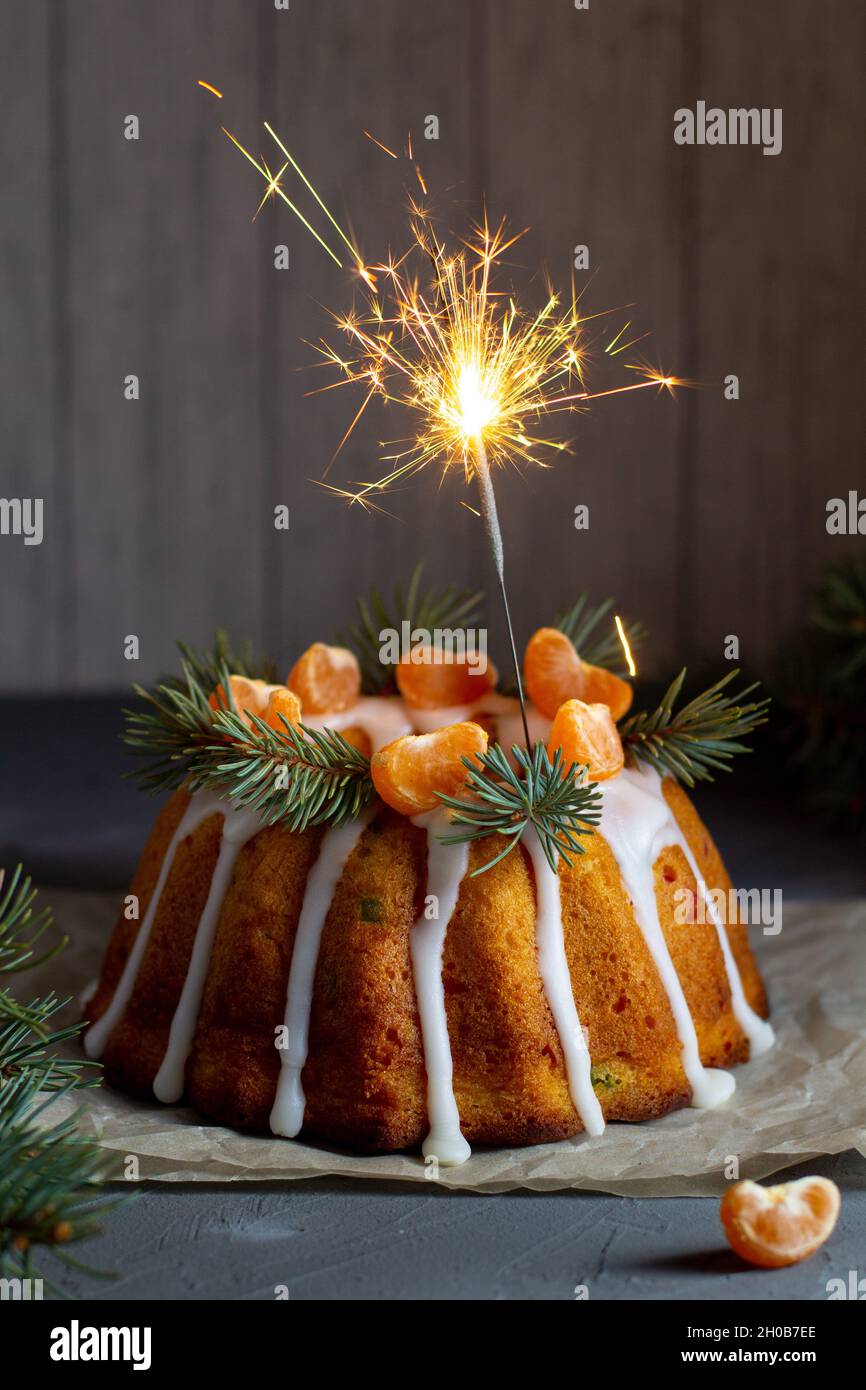 Gâteau de Noël aux fruits confits décoré de tranches de mandarine givrantes et de branches de sapin avec des biscuits.Noël fêtes concept de fête du nouvel an Banque D'Images