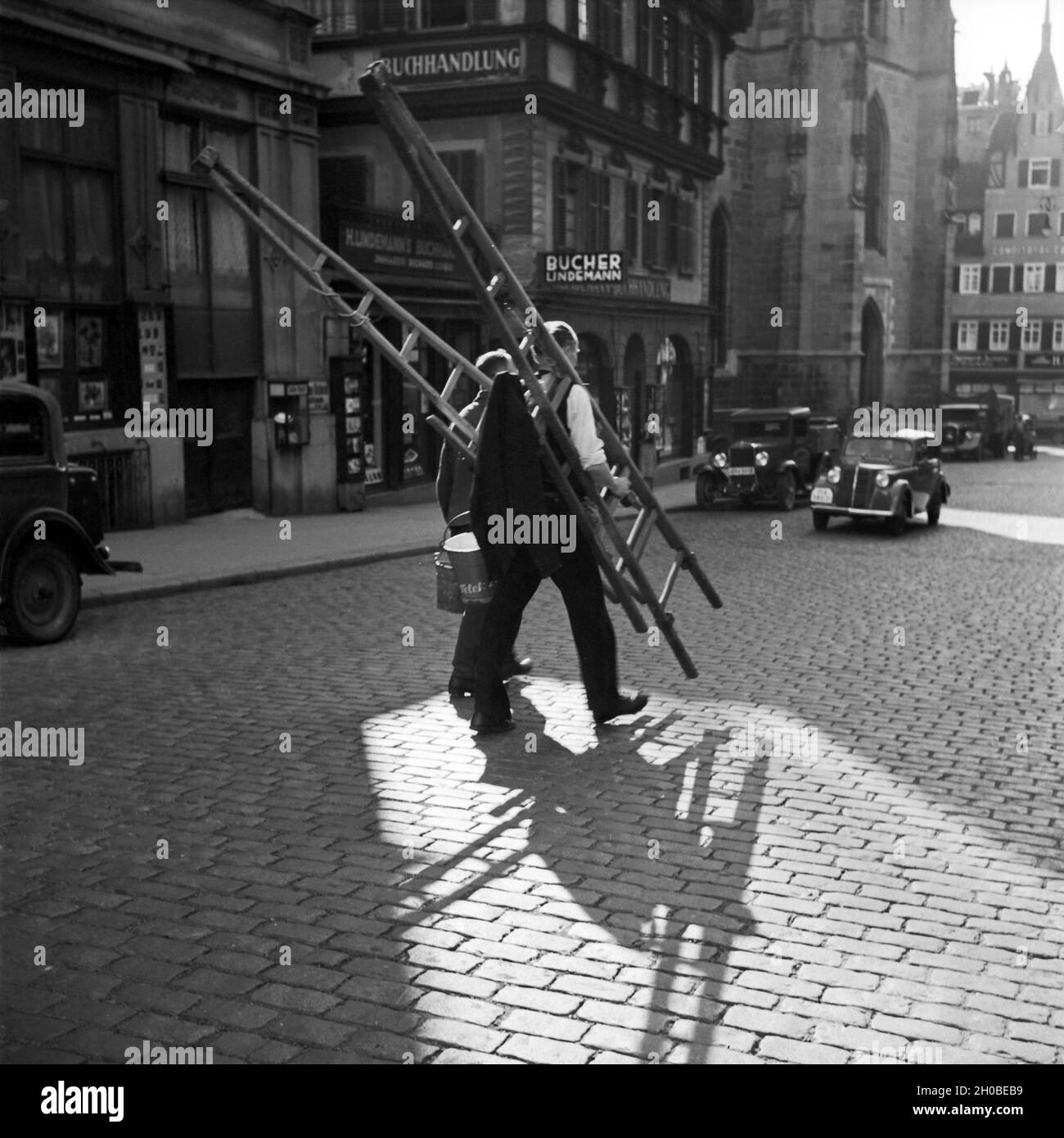 Zwei oder Fensterputzer Maler auf der Straße vor der Buchhandlung Lindemann à Stuttgart, Deutschland 1930 er Jahre. Deux peintres ou nettoyage de vitres de traverser la rue en face de Lindemann's book store à Stuttgart, Allemagne 1930. Banque D'Images