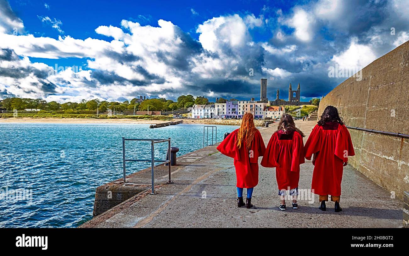 ST ANDREWS FIFE ECOSSE LE PORT ET LE MUR TROIS ÉTUDIANTS DE L'UNIVERSITÉ ET TROIS ROBES ROUGES Banque D'Images