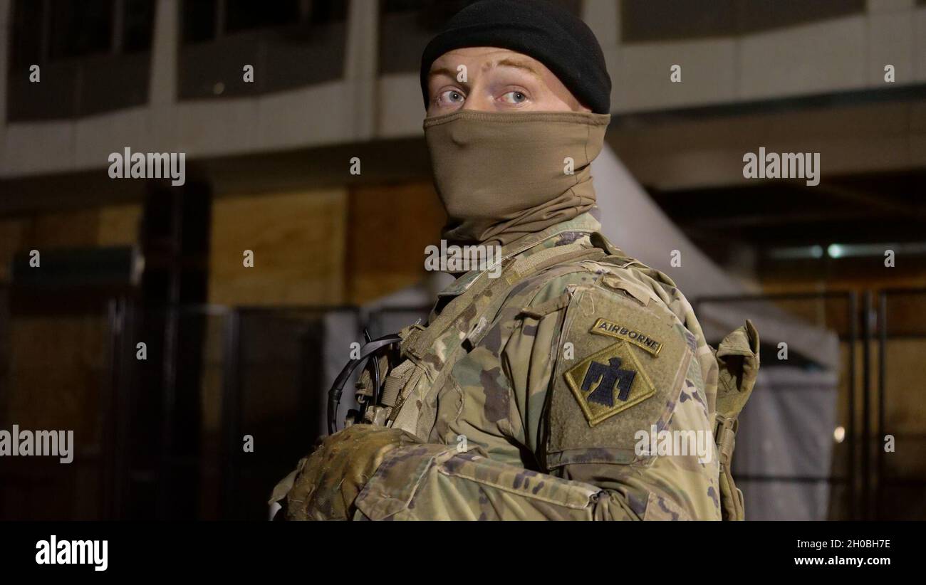 Un soldat américain de la Garde nationale de l'Indiana regarde son épaule tout en assurant la sécurité à Washington, D.C., le 18 janvier 2021.Au moins 25,000 hommes et femmes de la Garde nationale ont été autorisés à mener des missions de sécurité, de communication et de logistique à l'appui des autorités fédérales et de district qui ont mené et tout au long de la 59ème inauguration présidentielle. Banque D'Images