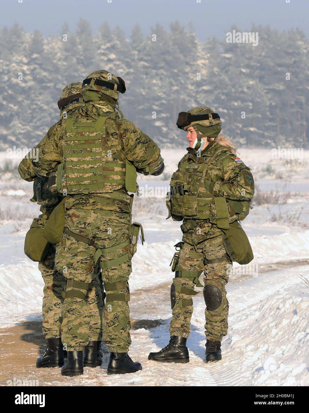 Les soldats de l'armée croate de l'OTAN ont renforcé leur présence avancée Groupe de combat-batterie Volcano-polonaise parlent alors qu'ils attendent de commencer le tir au pistolet pendant une période de qualification des armes le 19 janvier 2021 à Bemowo Piskie, Pologne. Banque D'Images