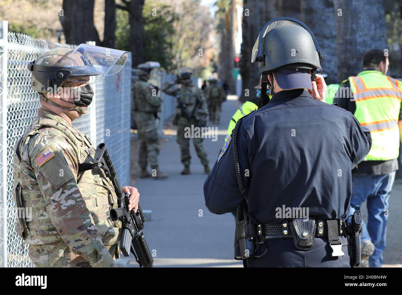 SPC de l'armée américaine.Alexander Kerkeles, de la 270e compagnie de police militaire, 185e Bataillon de police militaire, 49e brigade de police militaire, Garde nationale de l'armée de Californie, discute des opérations avec un officier de patrouille routière de Californie le 20 janvier 2021, au Capitole à Sacramento, en Californie.CAL Guardsmen continue à fournir une sécurité supplémentaire dans les installations fédérales et d'état alors que la nation se prépare à l'investiture du président nouvellement élu Biden. Banque D'Images