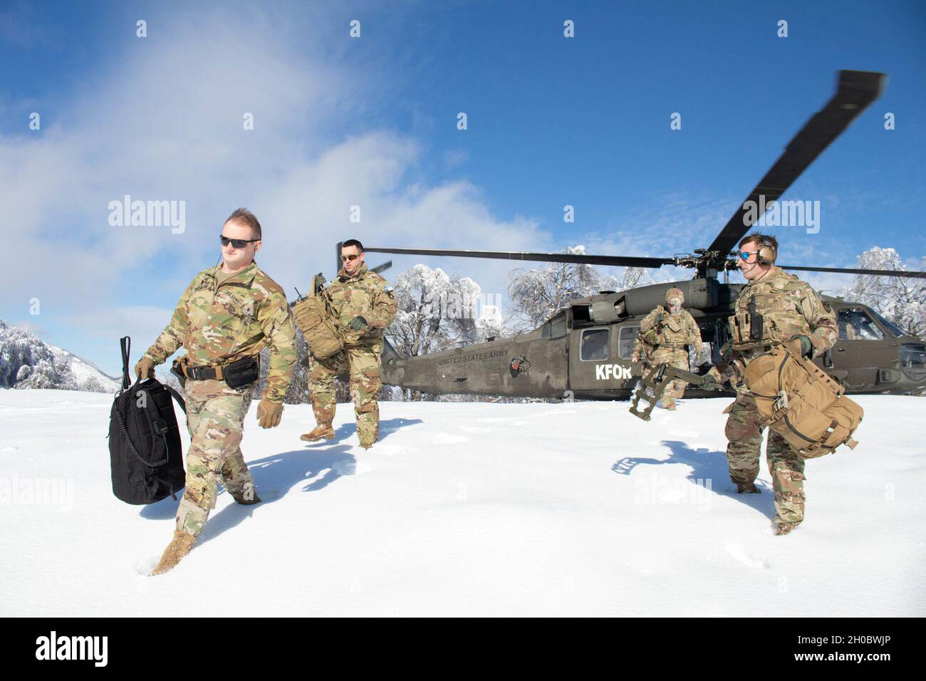 Des soldats affectés au Commandement régional-est de la Force du Kosovo, ont fait descendre un hélicoptère UH-60 Black Hawk lors d'une mission de déminage sur le site d'atterrissage d'un hélicoptère le long de la frontière administrative au Kosovo le 20 janvier 2021.Des missions régulières de SLH sont essentielles à la KFOR pour maintenir un environnement sûr et sécuritaire pour tous les habitants du Kosovo.La neige était trop profonde pour dégager complètement le site. L'équipage est donc revenu à la base et effectuera d'autres dégagements lorsque les conditions s'amélioreront. Banque D'Images