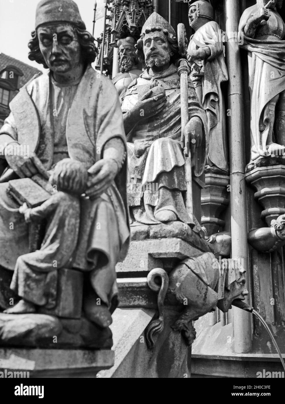 Figuren aus der Stadtgeschichte von Nürnberg Am Schönen Brunnen, Deutschland 1930 er Jahre. Les personnes de l'histoire de la ville de Nuremberg comme sculptures détaillées à la fontaine Brunnen Schoener, Allemagne 1930. Banque D'Images