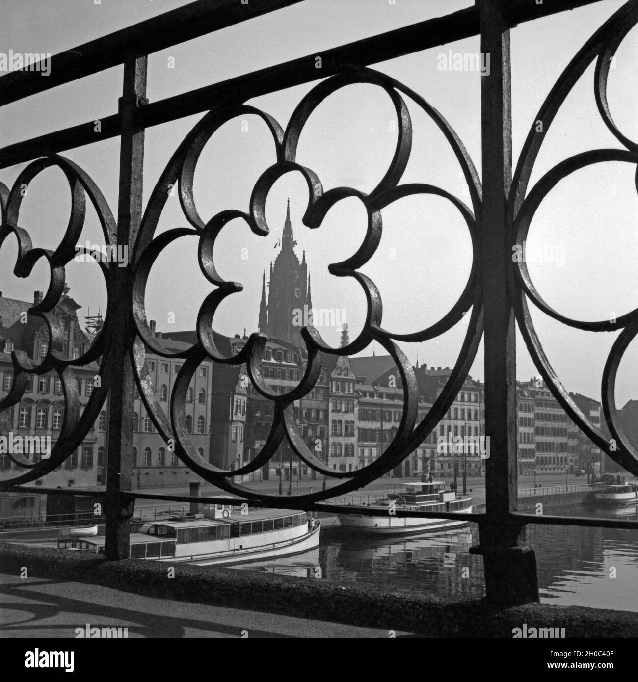 Der Kaiserdom St. Bartholomäus und dem Mainufer à Francfort durch eine im Rosette Geländer des Eisernen Stegs 1930er Jahre, Deutschland. Vue sur la ville de Francfort avec cathédrale et du Main, à travers la rambarde du pont Eiserner Steg, Allemagne 1930. Banque D'Images