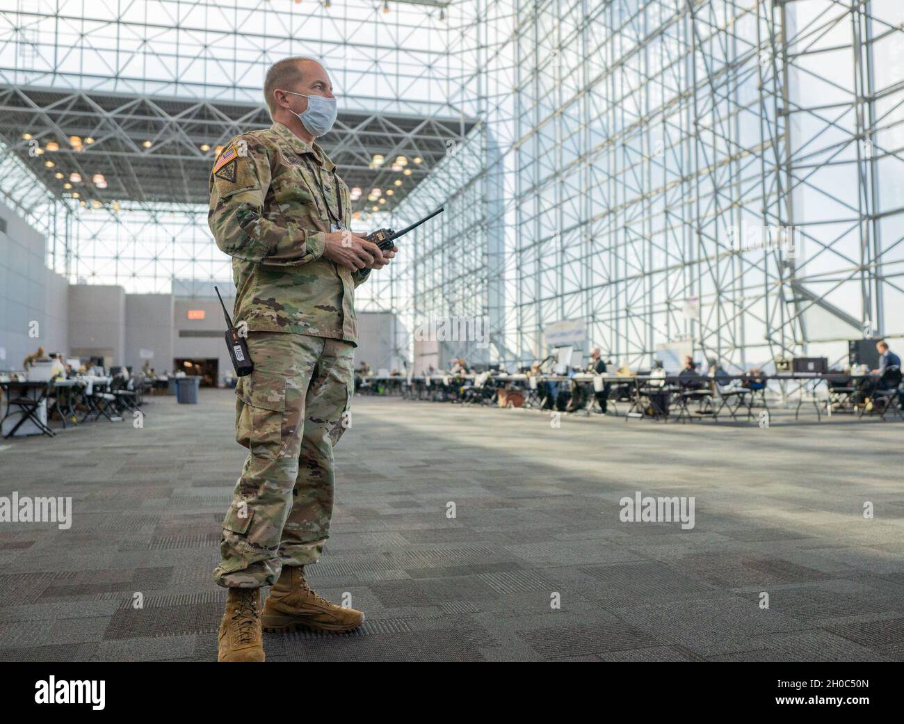 Le colonel de l'armée américaine Richard Green, commandant du commandement médical de la Garde nationale de New York, affecté à la 466e compagnie médicale,Se tient prêt sur tous les canaux tout en écoutant un briefing dans sa dernière semaine en tant que commandant de bataillon pour soutenir les efforts de l'État pour fournir des vaccinations de masse COVID-19 administrées par le département de la santé de l'État de New York au Centre de congrès Javits à Manhattan, New York, le 21 janvier 2021.La Garde nationale compte plus de 350 gardiens et femmes déployés sur le site de vaccination pour soutenir le personnel du site.Le Département de la santé de l'État de New York procède à la vaccination Banque D'Images