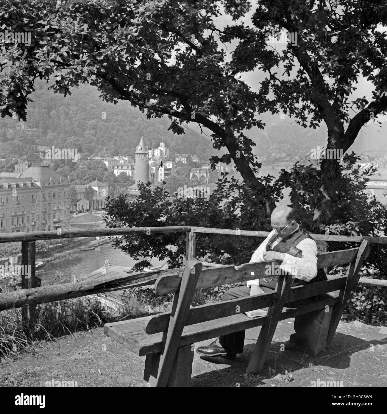 Ein Mann lesend sitzt auf einer Bank Am Ufer der Lahn à Bad Ems, Deutschland 1930 er Jahre. Un homme lisant sur un banc à Bad Ems, Allemagne 1930. Banque D'Images